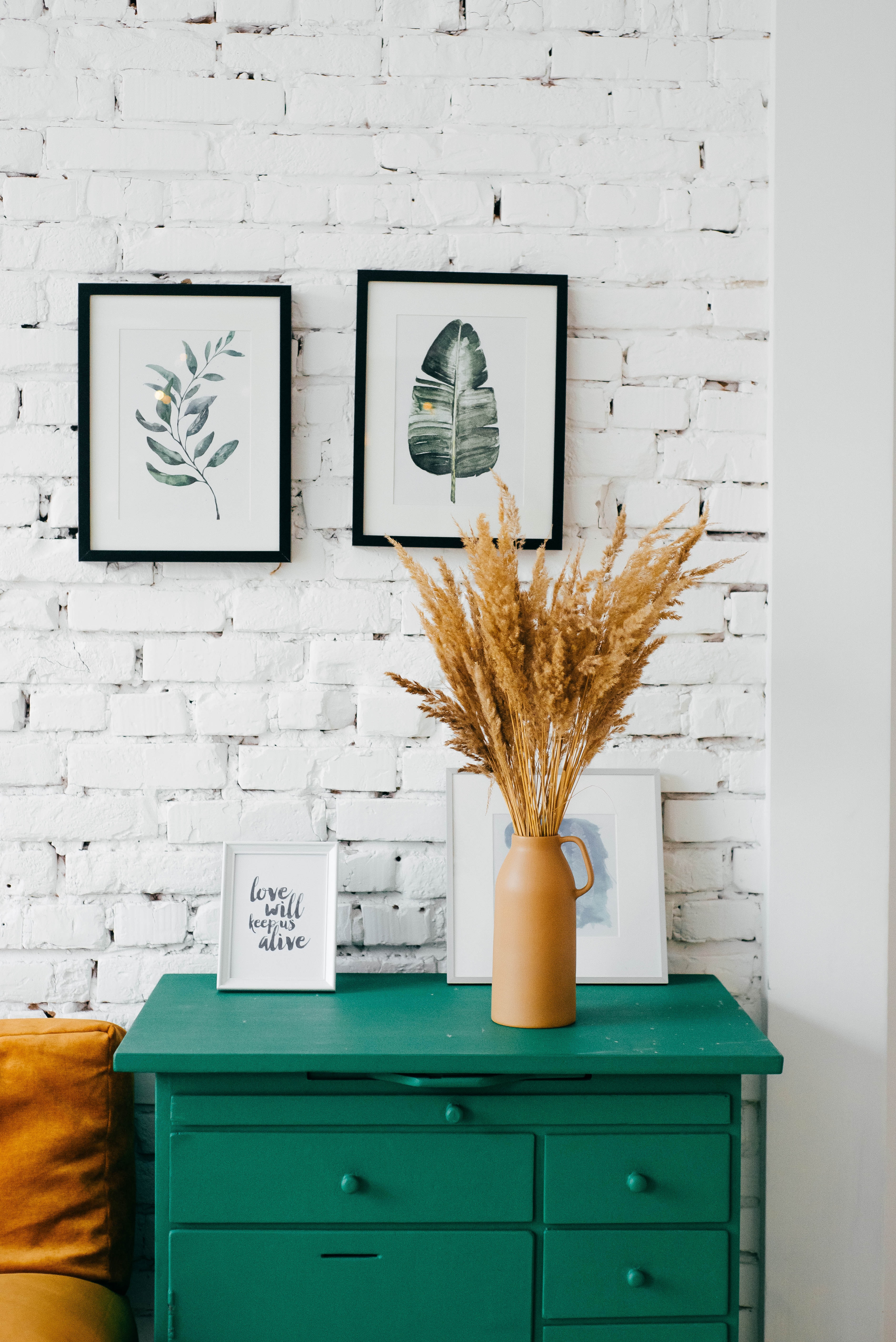 photo of furniture with some paintings on the wall behind 